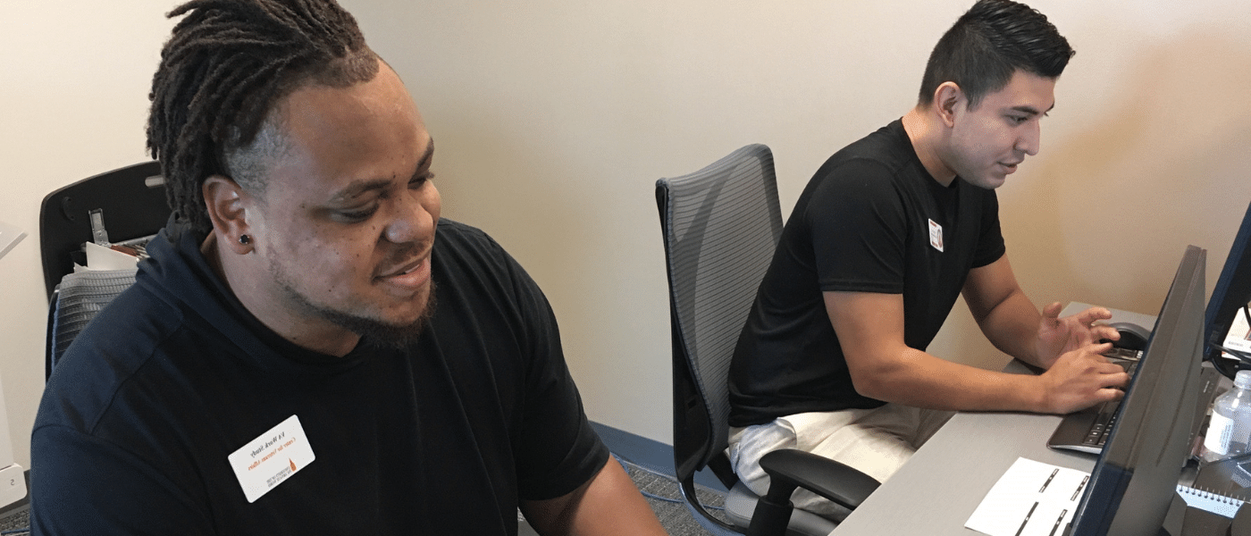 Two veteran student workers sitting at the front desk.