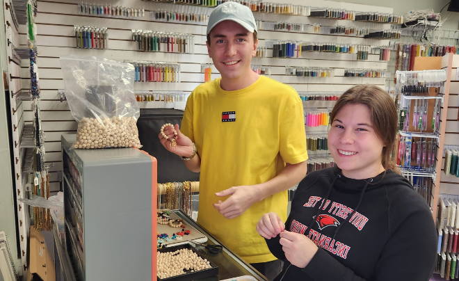 Two students help make jewelry 