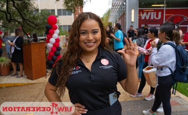 UIW student holding up the Cardinal sign