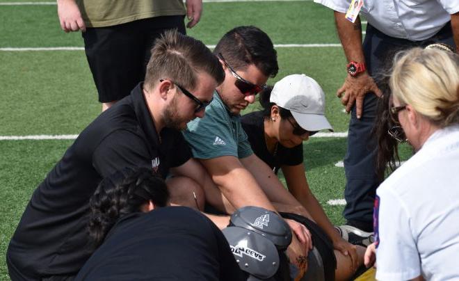 Dr. Sterling Jeffries and Dr. Edgardo Rivera Lopez work on an athlete