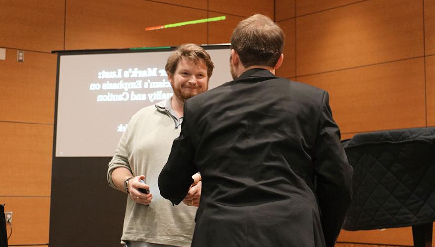 Rerick shaking hands with Dr. 凯恩